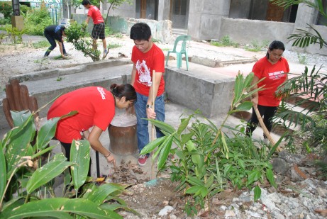 Teachers Christine and Delfin work together to clean the garden at General Roxas Elementary School.