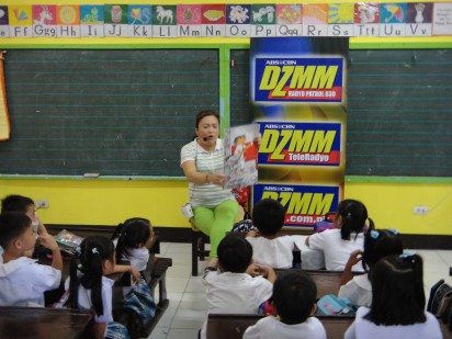 Tita Winnie reads a story in front of Grade 1 students.