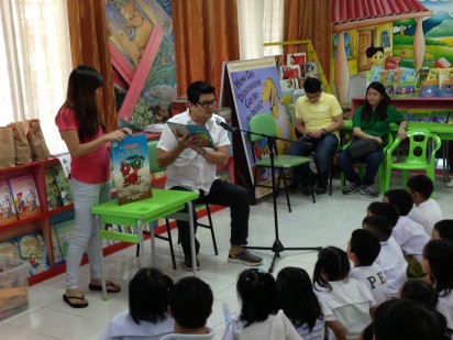 Julius Babao reads "Si Langgam at si Tipaklong" to a class of Grade 1 students.